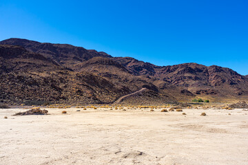 Dark brown desert mountain with hiking trail in the Mojave Desert