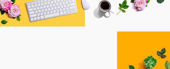 Computer keyboard and a mouse with pink roses - flat lay