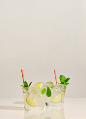 A pair glasses of Mojito cocktail on white marble table. With copy space for your text.