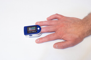 Pulse oximeter on finger measures pulse rate and hemoglobin oxygen saturation