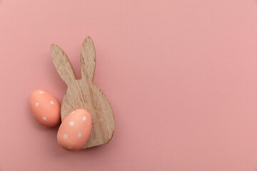 Minimal easter holiday background. Wooden easter bunny and egg on pink