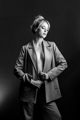 Sexy young blonde, a jacket dressed on a naked body. The model is looking down.