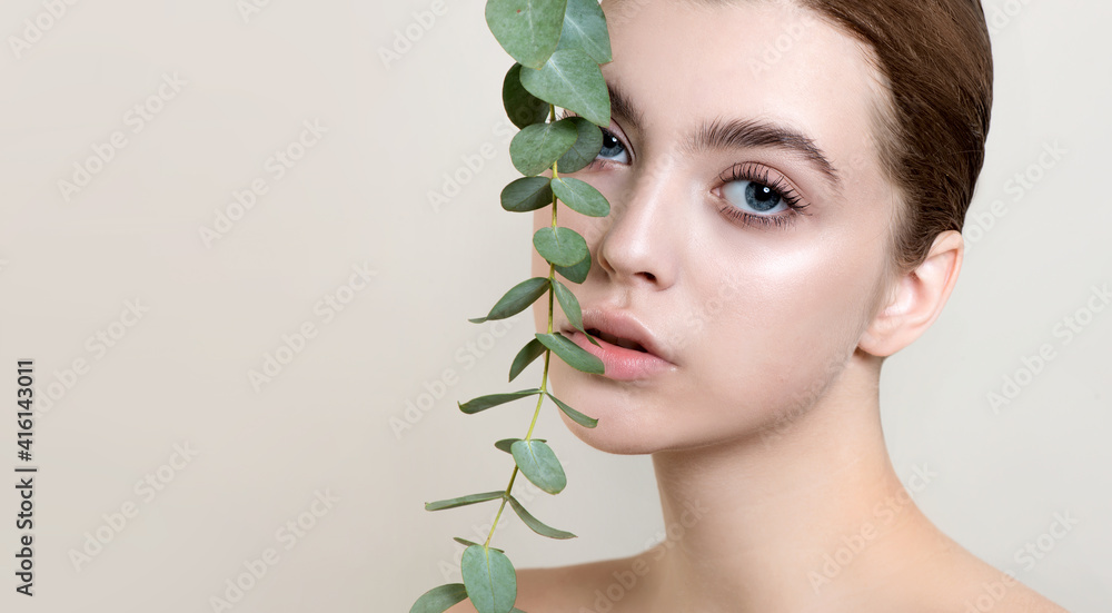 Wall mural portrait of beauty model with natural nude makeup with eucalyptus leaf branch.