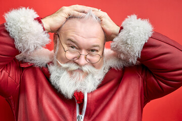 aged caucasian man grabbed head, look at camera looking awesome. isolated red background