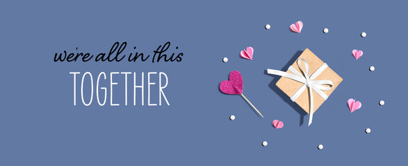 We are All in This Together message with a small gift box and paper hearts