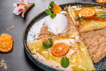 Delicious fresh pancakes on a plate with sweet sauce and ice cream decorated with mint