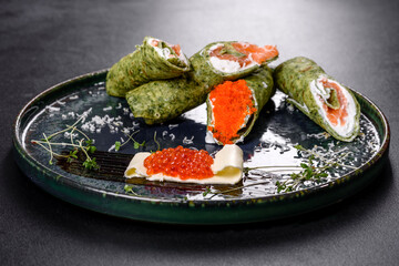 Delicious fresh sweet pancakes on a plate with red fish and caviar