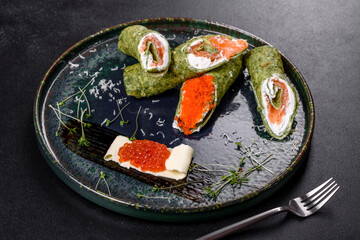 Delicious fresh sweet pancakes on a plate with red fish and caviar