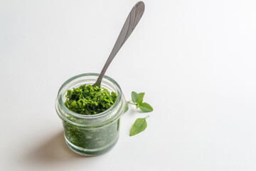 pesto sauce in a jar take a spoon. Close shot