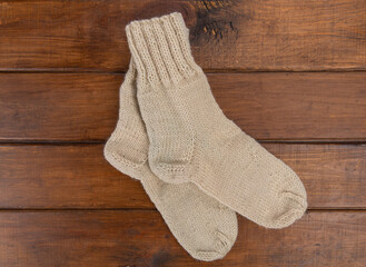 Top view on beige woolen socks on a wooden background