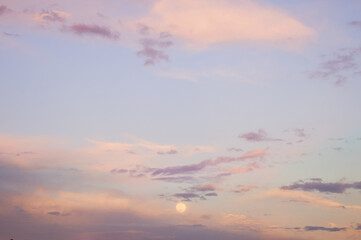 Moon between the clouds and the sunset view