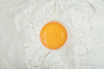 Flour with raw yolk on a gray background