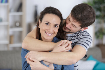 affectionate couple embracing woman looking at camera