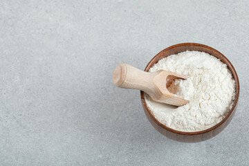 Fototapeta na wymiar A wooden bowl of flour and wooden spoon