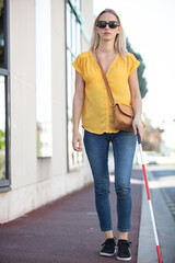 blind woman walking on sidewalk