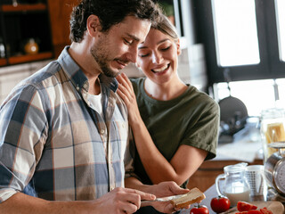 Husband and wife in kitchen. Young couple preparing delicious food at home..