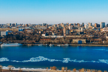 Fototapeta premium Panoramic view of Don river and right bank of Rostov-on-Don city with many buildings, Russian big city in winter time aerial view.