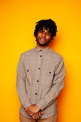 Fototapeta premium young handsome african american guy student posing cheerful and gesturing on yellow background, lifestyle people concept