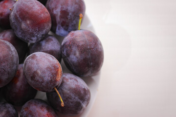 Appetizing ripe plums on a white background with copy space