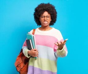 young student afro woman looking angry, annoyed and frustrated screaming wtf or what’s wrong with...