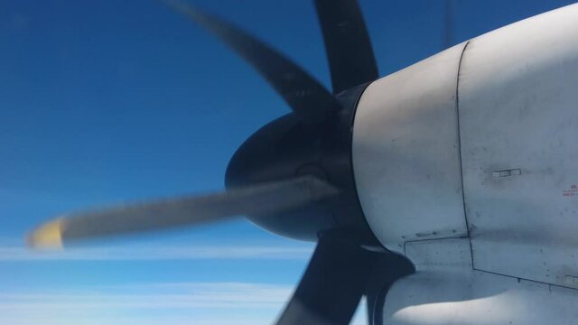 The rotor of a propeller plane during flying over the ocean - view from the passenger seat
