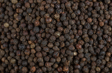 Background pile of black dried healthy peppercorns