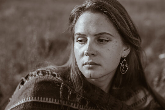 black white photo close-up. The face of a girl looking with a sad look of half-dropped eyes. High quality photo