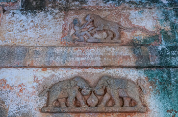 Chitradurga, Karnataka, India - November 10, 2013: Fort or Elusuttina Kote. Animal themed, tiger and elephant, small sculptures on inner rampart lock wall. Brown and gray tints.