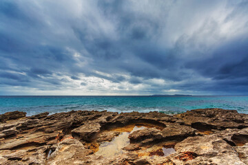 Fototapeta na wymiar Rocky beach under a gloomy dramatic sky