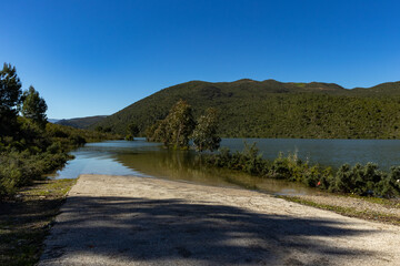 The dam is full and the water rises to the road