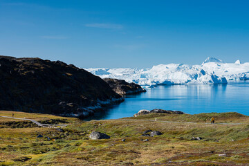 Fototapeta na wymiar Greenland. Ilulissat. Visitors on the boardwalk leading to the Icefjord.