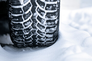 Winter studded tire tread standing in the snow close up