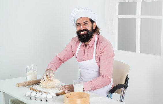 male cook preparing food in restaurant kitchen. brutal hipster in apron cooking meal. time for eating. happy baking. concept of housekeeping. making fresh dough. mature bearded man wear chef hat