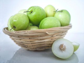 Indian jujube fruit or Ziziphus mauritiana or buah bidara in a rattan bowl. Blurred background