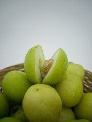 Indian jujube fruit or Ziziphus mauritiana or buah bidara in a rattan bowl. Blurred background