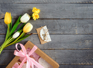 Spring yellow tulips and gifts on wooden background. Concept of holiday, birthday, easter, womens day. Flat lay