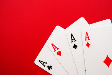 Four poker cards of aces on red background. Four playing cards of aces