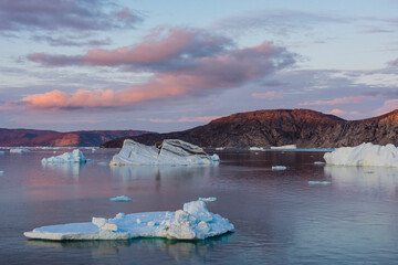 Greenland. Disko Bay. Sunset with icebergs and the arid coast of Greenland.