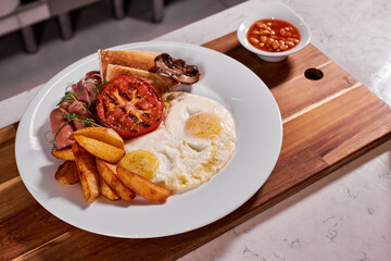 Fried Eggs, tomatoes, fries and sausages on plate, copy space. eating, food, restaurant nutrition concept