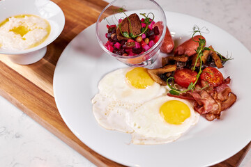 Fried Eggs With Bacon, Tomato and Salad Served At Cafe Table On Wooden Board , English Breakfast. Food, Restaurant concept