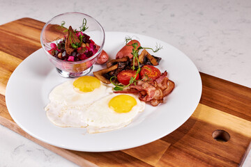 Fried Eggs With Bacon, Tomato and Salad Served At Cafe Table On Wooden Board , English Breakfast. Food, Restaurant concept