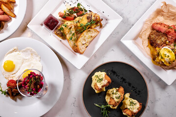 Big variety of delicious food on table flat lay, in restaurant. Beautifully and professionally cooked served meal for guests in rich restaurant. top view