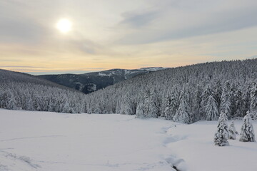 The sun going down in the snowy mountains at Jeseniky, Czech republic