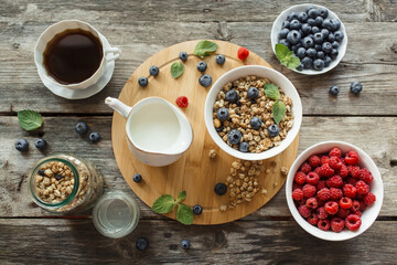 Obraz na płótnie Canvas Breakfast with muesli, fresh berries, coffee on wood background. Healthy food concept. Flat lay, top view.