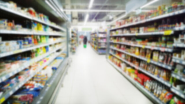 Abstract blur image of supermarket background. Defocused shelves with fresh products. Grocery shopping. Store. Retail industry. Food quality. Rack. Discount. Inflation and crisis concept. Aisle.