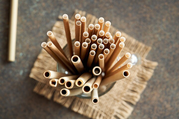 Bamboo and paper straws on a table - zero-waste or ecology concept