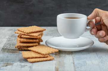 Aroma cup of tea with tasty crackers on a wooden table