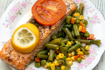 Salmon with juicy vegetables like pea, carrots and corn