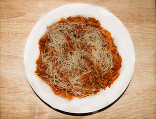 Spaghetti Bolognese in white plate on wooden background