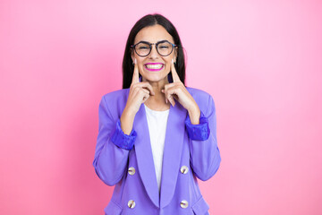 Young business woman wearing purple jacket over pink background smiling confident showing and pointing with fingers teeth and mouth